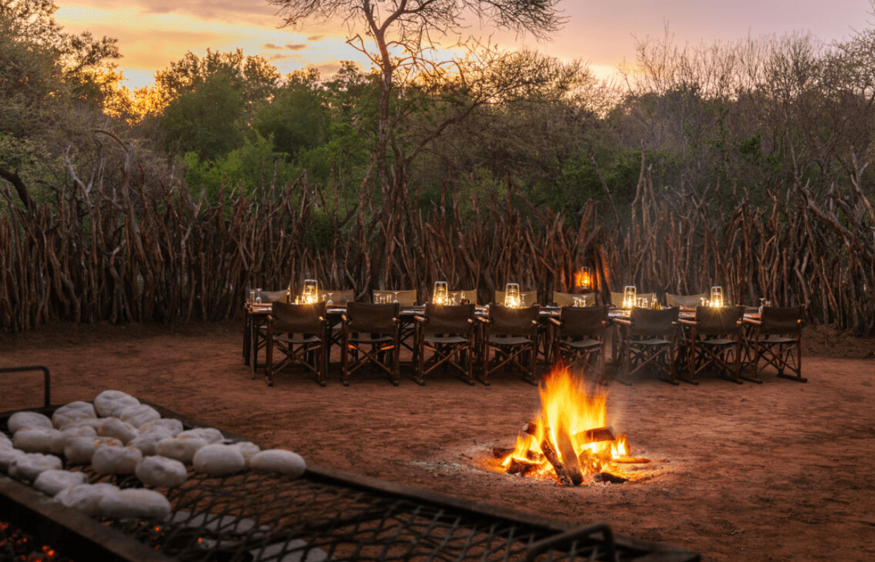 S006-IT2 - Fire Burning and Dinner Table Set Outside Sustainable Safaris Africa - Journeys - Luxury Madikwe Family Safari - Fire Burning and Dinner Table Set Outside