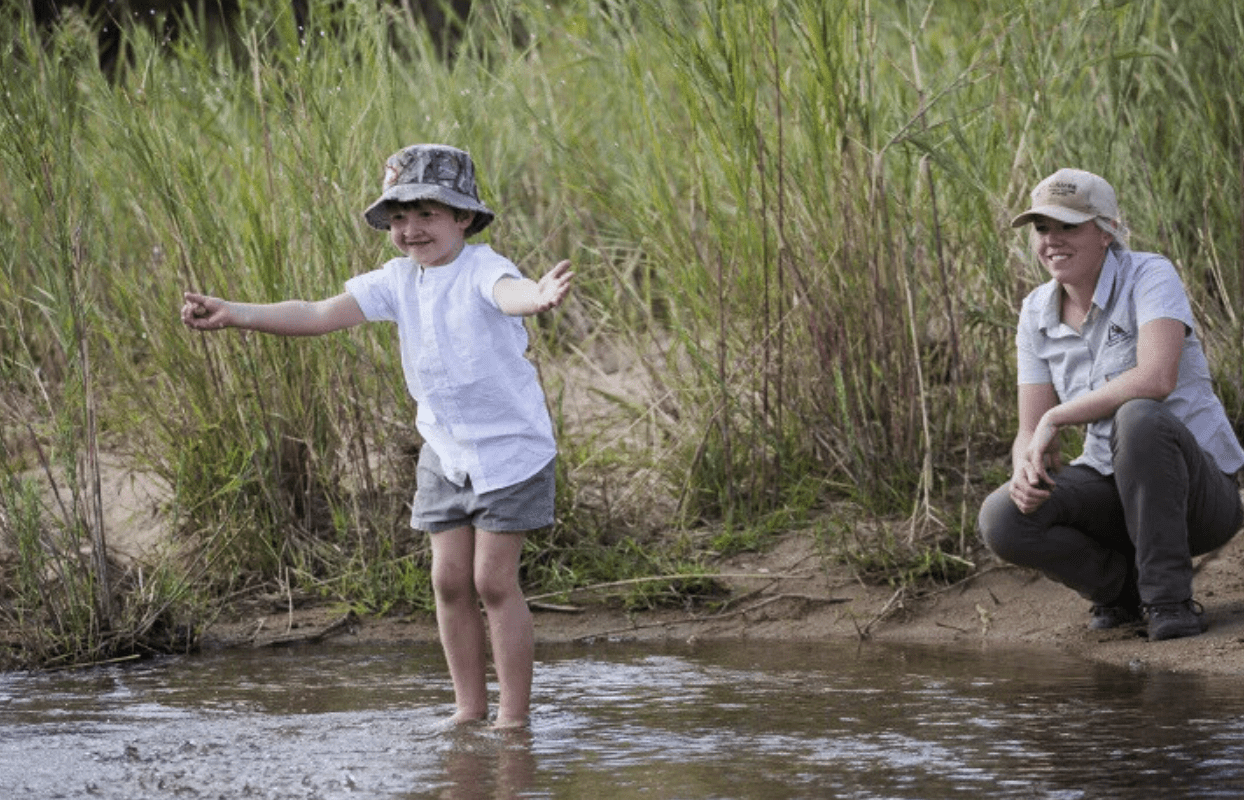 S002-IT1 - Little Boy Playing in the River on a Game Drive with Safari Guide Sustainable Safaris Africa - Journeys - Luxury Kruger Safari - Little Boy Playing in the River on a Game Drive with Safari Guide