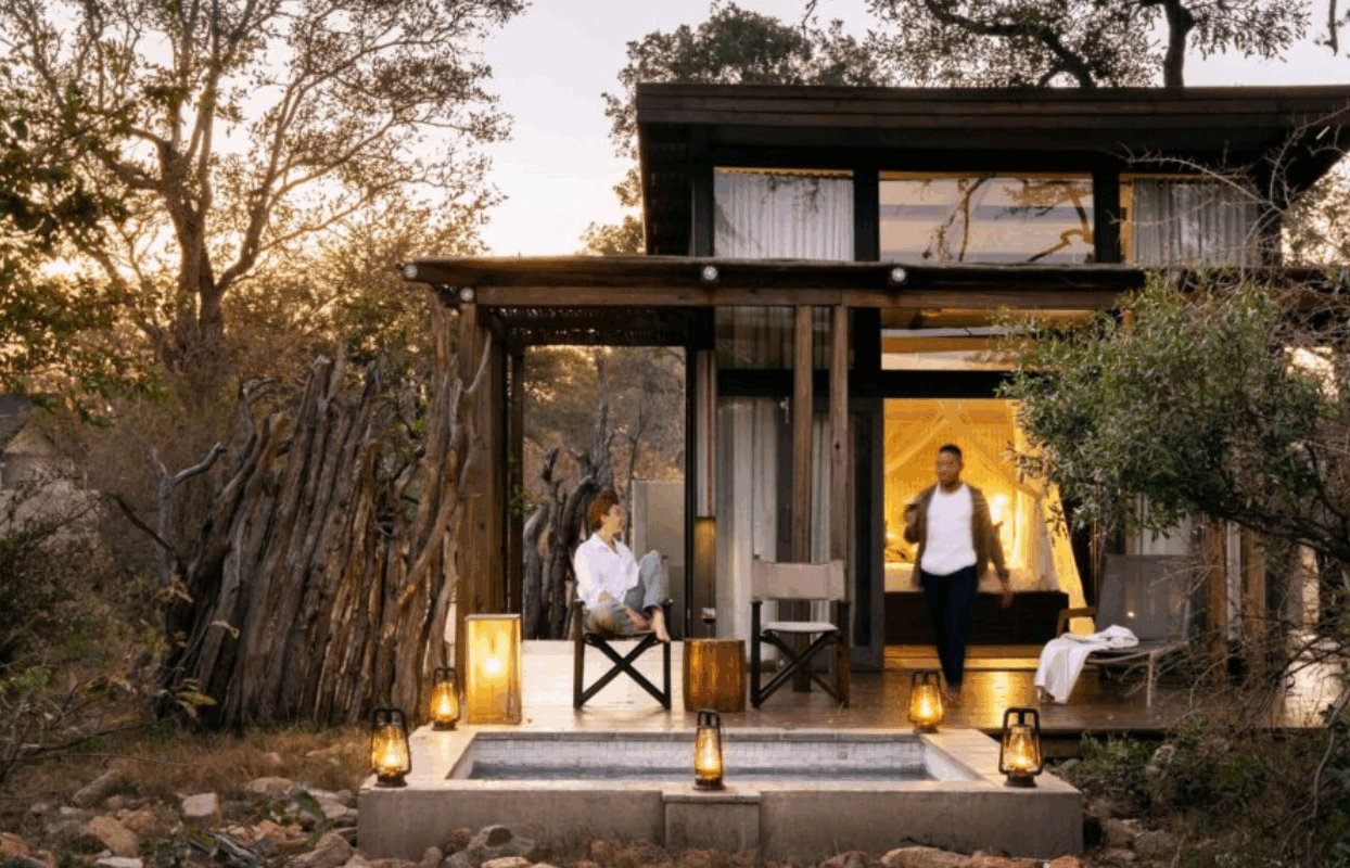 S003-IT2 - Couple Outside of Safari Lodge at Dusk Sustainable Safaris Africa - Journeys - Family Friendly Kruger Safari - Couple Outside of Safari Lodge at Dusk