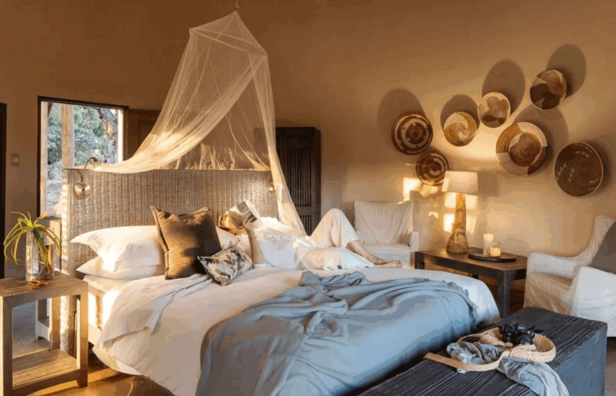 S003-IT2 - Man Lying on Bed in Luxury Accommodation Bedroom Suite Accommodation Sustainable Safaris Africa - Journeys - Family Friendly Kruger Safari - Man Lying on Bed in Luxury Accommodation Bedroom Suite Accommodation