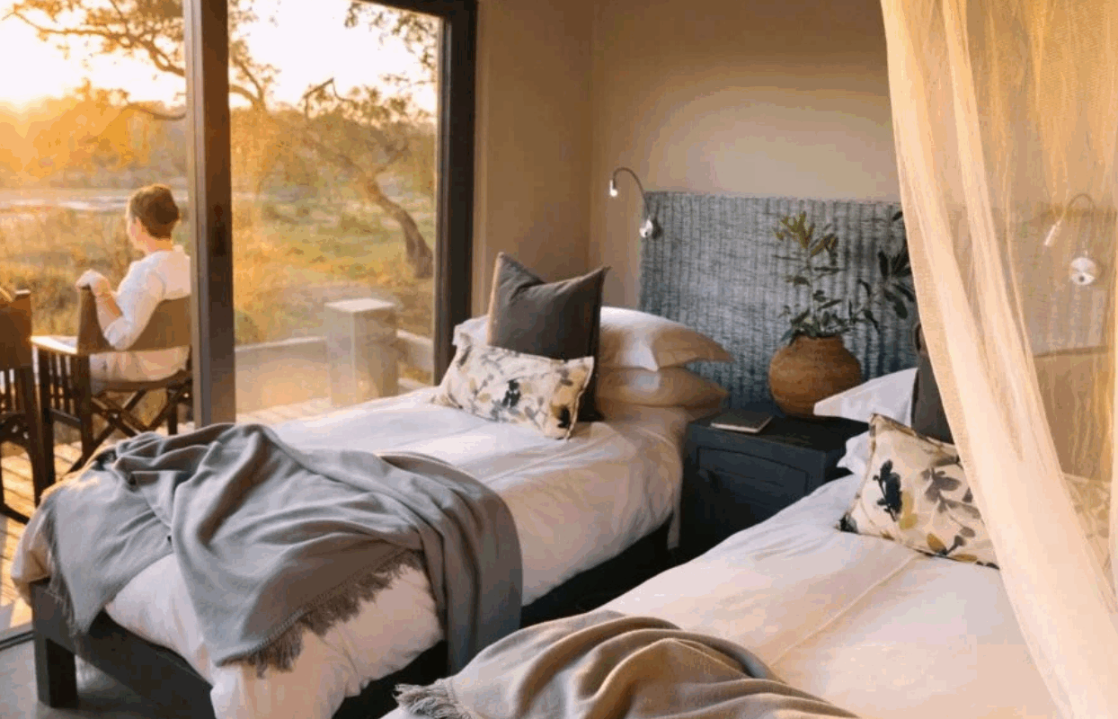 S003-IT2 - Couple Sitting on the Balcony of Bedroom Suite and Single Beds Sustainable Safaris Africa - Journeys - Family Friendly Kruger Safari - Couple Sitting on the Balcony of Bedroom Suite and Single Beds